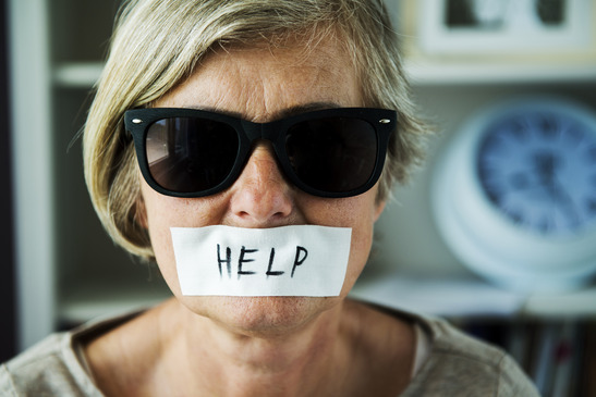 Senior woman with sunglasses and tape on her mouth, victim of domestic violence